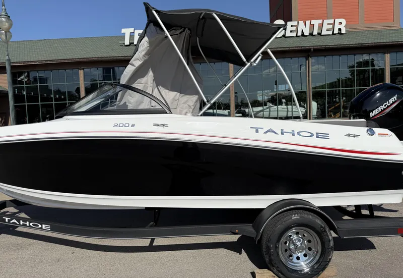 Slide: The Image of 2024 Tahoe 200 S boat with black and white design, parked outside a showroom. - 10