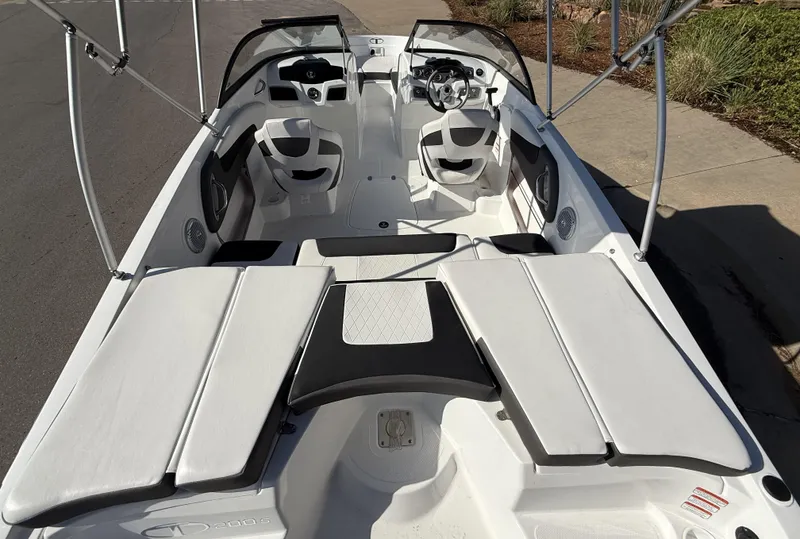 Slide: The Image of 2024 Tahoe 200 S boat interior with seating and steering wheel, docked on a sunny day. - 4