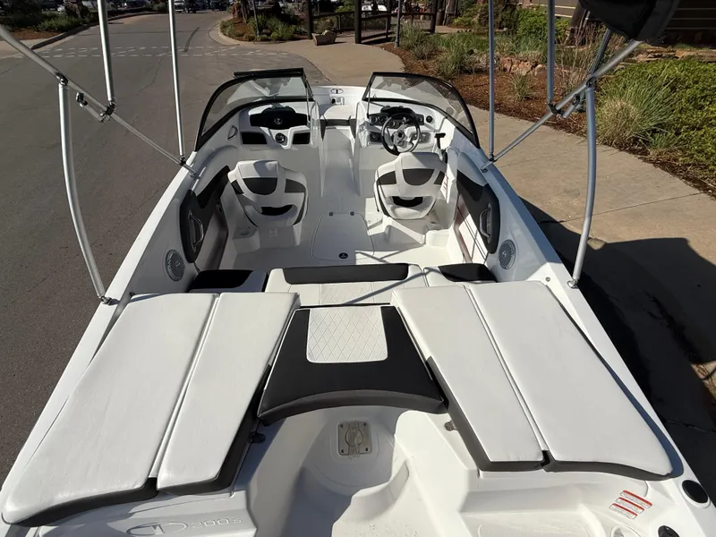 Slide: The Image of 2024 Tahoe 200 S boat interior with seating and steering wheel, parked on a street. - 9