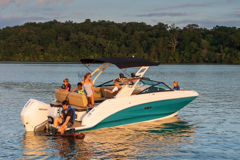 Slide: The Image of 2024 Sea Ray SDX 250 Outboard boat on a lake with passengers enjoying the water. - 0