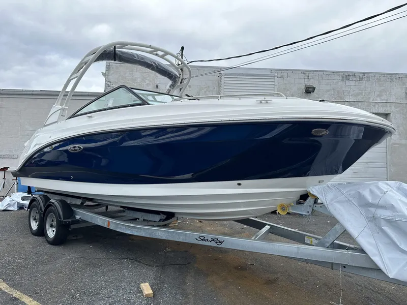 Slide: The Image of 2024 Sea Ray SDX 250 Outboard boat on trailer, blue and white design. - 1