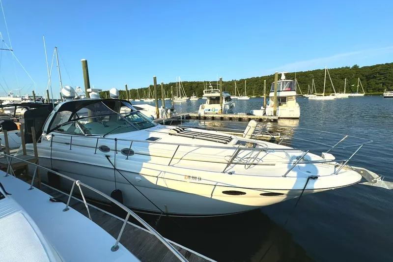 Slide: The Image of 2003 Sea Ray 38 Sundancer yacht docked in a marina under clear blue skies. - 1
