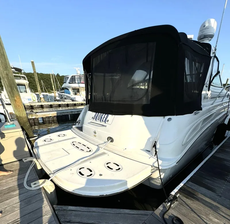 Slide: The Image of 2003 Sea Ray 38 Sundancer docked with black canopy, rear view. - 2