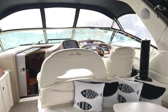 Slide: The Image of Interior of 2003 Sea Ray 38 Sundancer yacht with plush seating and nautical-themed pillows. - 5