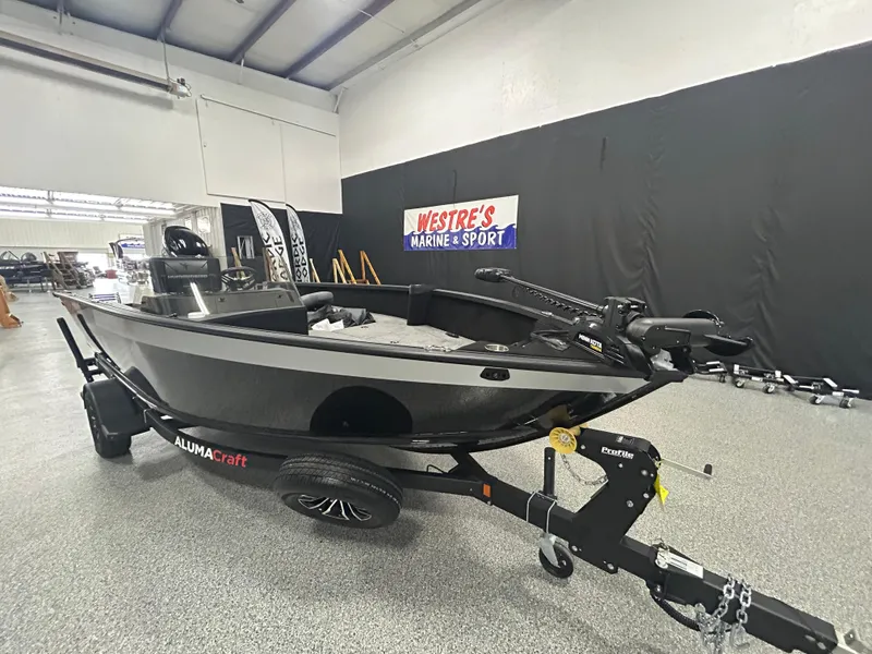 Slide: The Image of 2025 Alumacraft Competitor 175X CS boat displayed in a showroom with fishing equipment. - 2