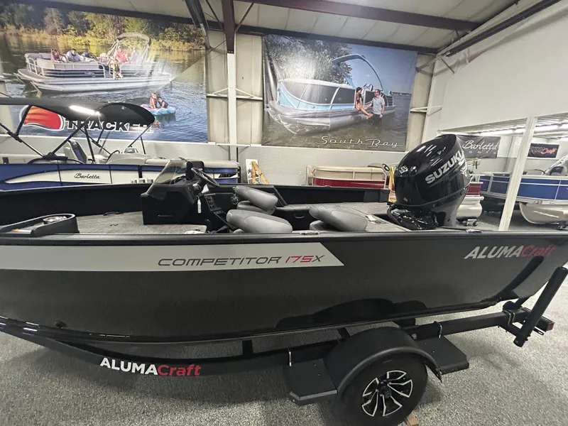 Slide: The Image of 2025 Alumacraft Competitor 175X CS boat interior with seating and controls in showroom. - 4