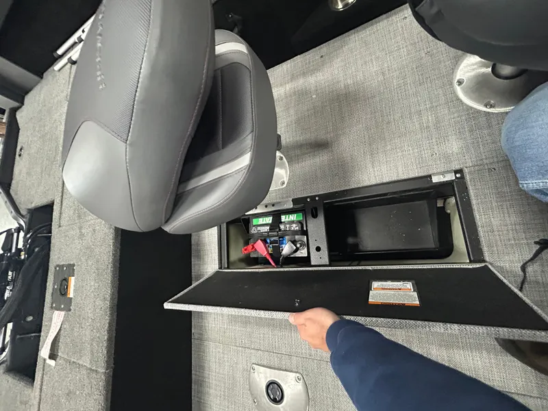 Slide: The Image of 2025 Alumacraft Competitor 175X CS boat storage compartment with carpeted interior and visible latch mechanism. - 7