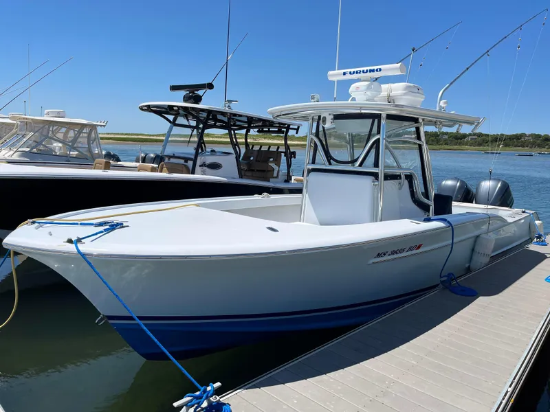 Slide: The Image of 2006 Croswait 28CC boat docked, featuring sleek design and dual engines. - 1