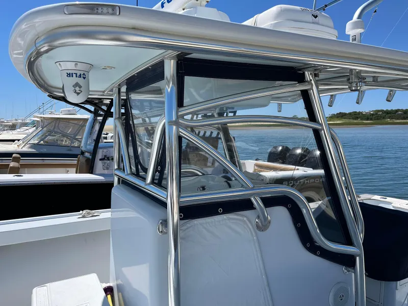 Slide: The Image of 2006 Croswait 28CC boat with sleek design and stainless steel frame, docked by the water. - 4