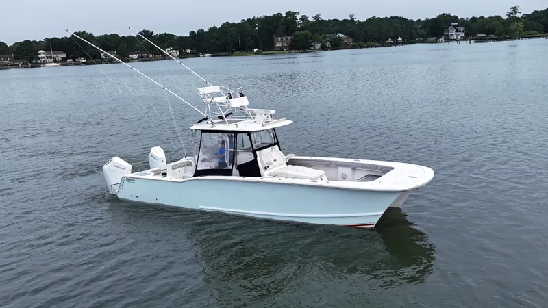 The Image of A white boat on calm water, featuring two outboard engines and fishing rods. - 0