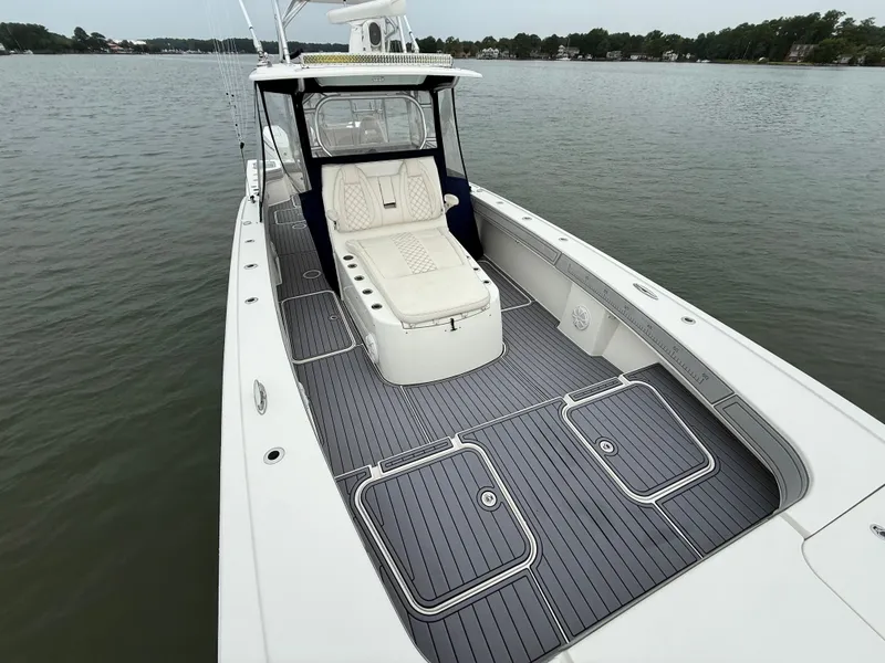 Slide: The Image of The image shows a 2020 Tideline 365 Offshore boat on calm water. It features a spacious deck with white seating. - 24