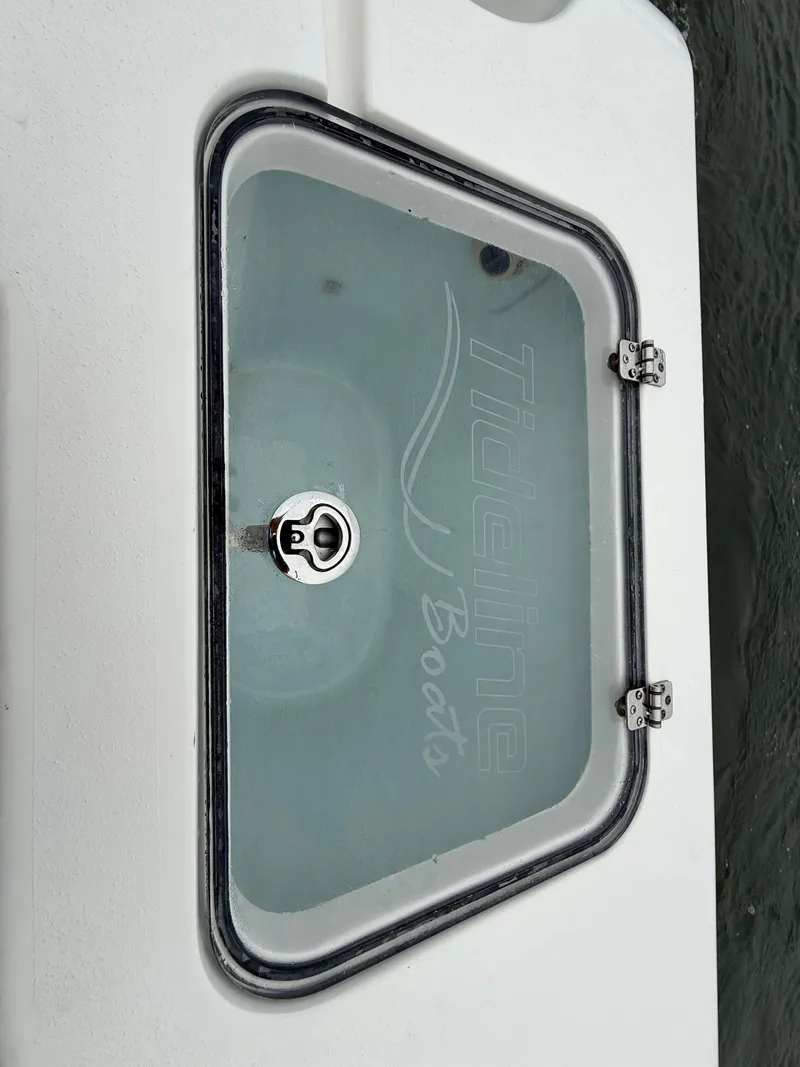 Slide: The Image of A glass hatch with the Tideline Boats logo on a white boat. - 17