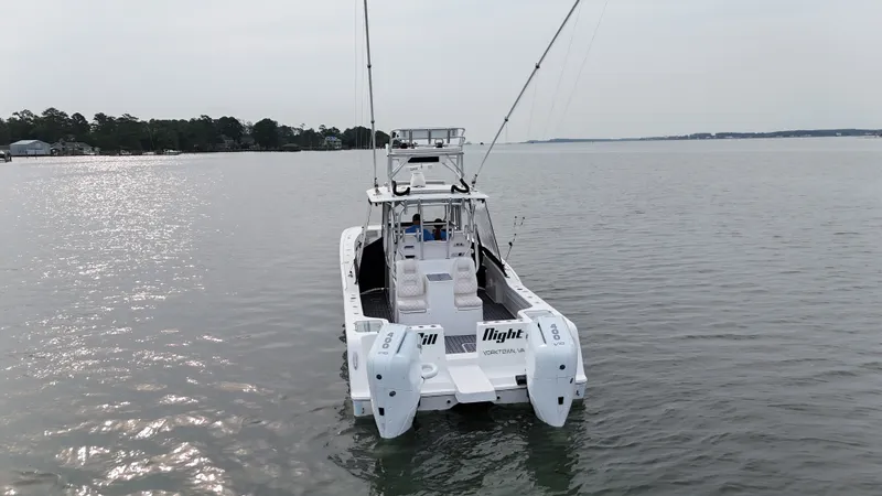 Slide: The Image of A 2020 Tideline 365 Offshore on calm water, featuring dual outboard engines and fishing rods. - 40