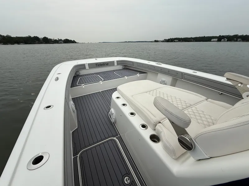 Slide: The Image of The image shows the deck of a 2020 Tideline 365 Offshore boat on calm waters. - 21