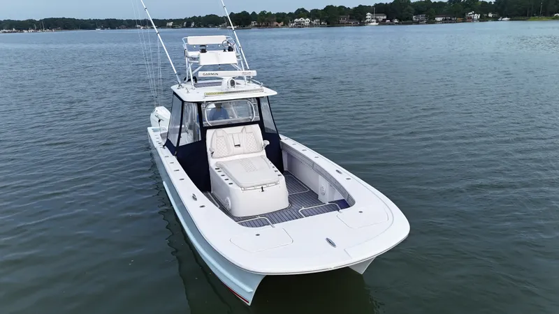 Slide: The Image of A white boat floating on calm water, featuring a spacious deck and a helm station. - 46