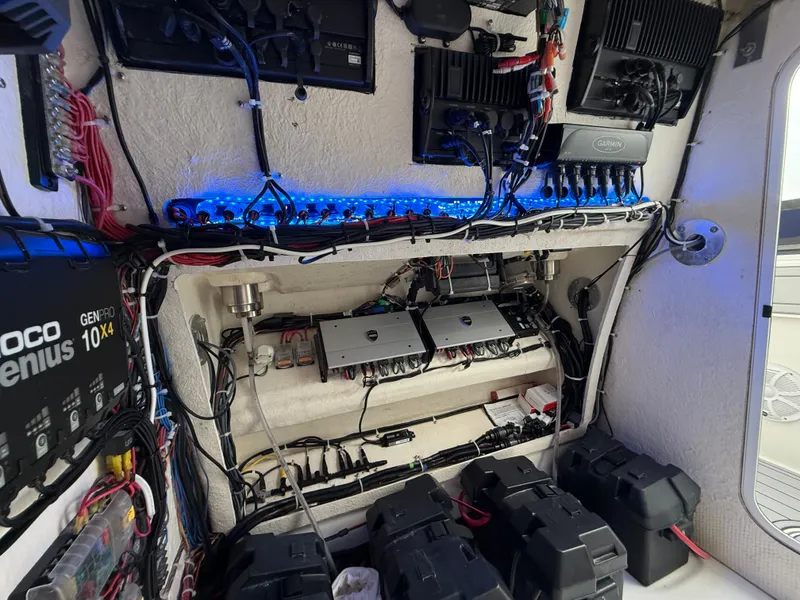 Slide: The Image of Electronics and battery systems inside a boat, featuring cables and control boxes. - 32