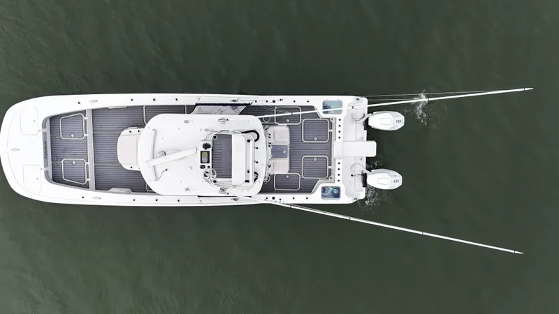 Slide: The Image of Aerial view of a white boat on the water with two outboard motors and fishing rods. - 2