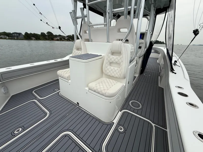 Slide: The Image of The image shows the deck of a 2020 Tideline 365 Offshore boat with sleek seating and gray flooring. - 10