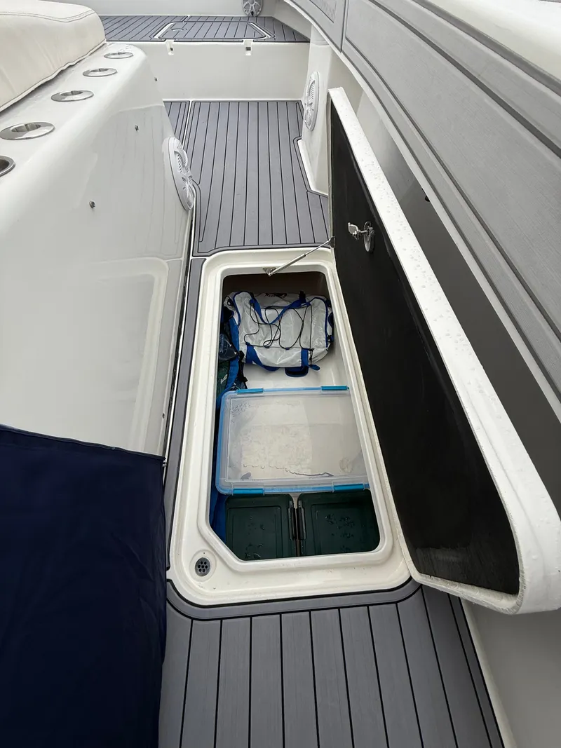 Slide: The Image of An open storage compartment on a boat with gray flooring and white side walls. - 28