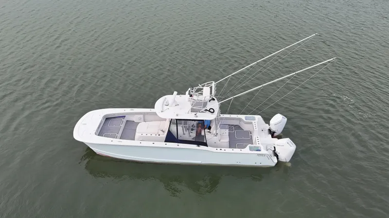 Slide: The Image of A white boat floating on calm water, featuring two outboard engines and a covered helm console. - 44