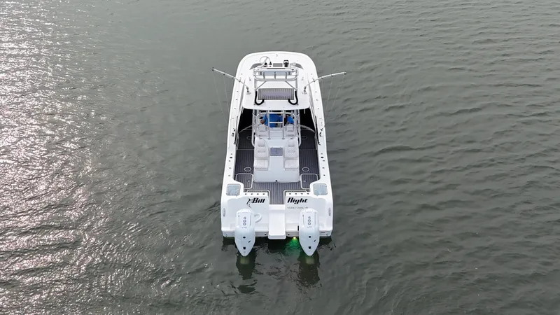 Slide: The Image of The 2020 Tideline 365 Offshore is a sleek boat with dual outboard engines on calm water. - 41