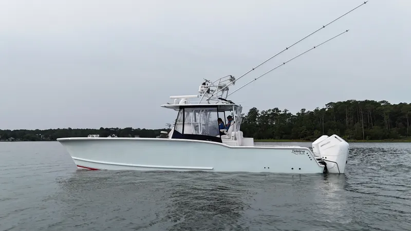 Slide: The Image of A 2020 Tideline 365 Offshore boat on calm water with two outboard engines and fishing rods. - 3
