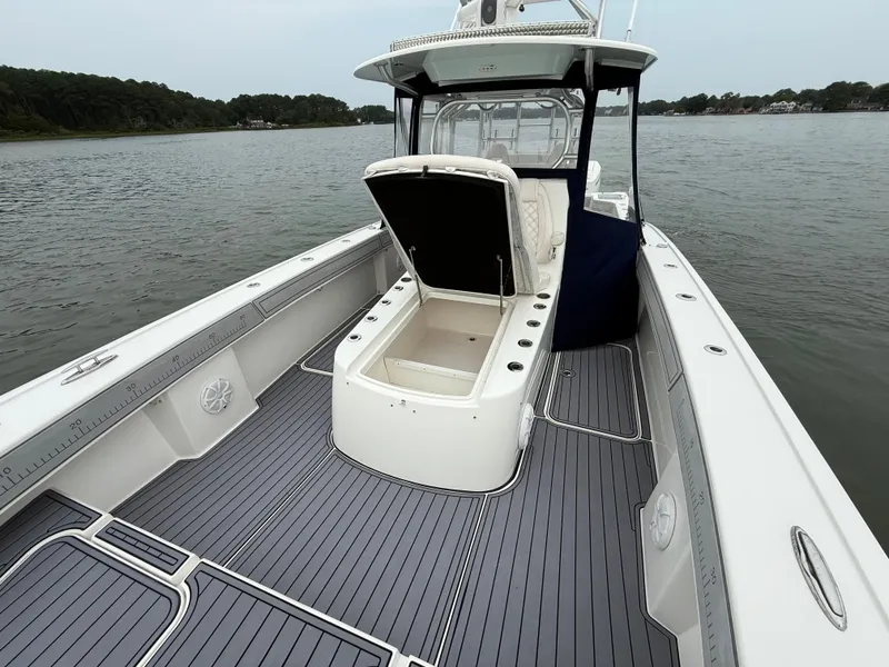 Slide: The Image of The image shows a 2020 Tideline 365 Offshore boat on the water. It features an open deck with a central storage area. - 26