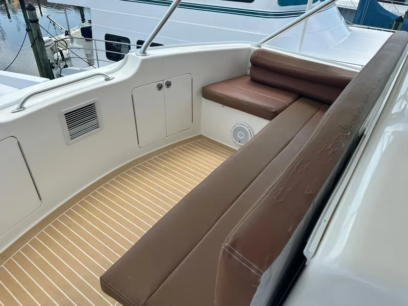 Slide: The Image of 2005 Post 53 Convertible yacht seating area with brown cushions and wood flooring. - 22