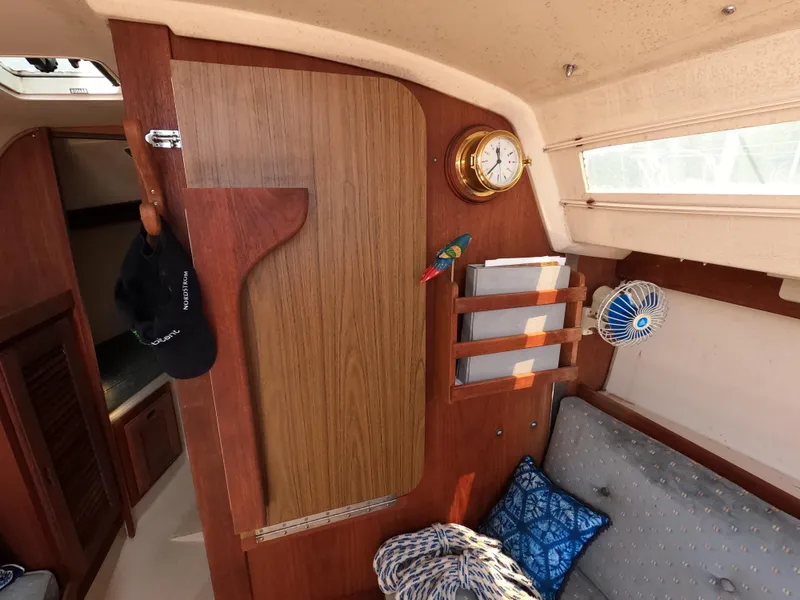 Slide: The Image of Interior of 1985 Catalina 27 sailboat with wood paneling and nautical decor. - 11