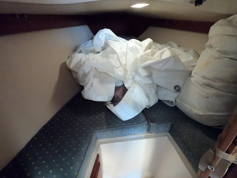 Slide: The Image of V-berth storage area in 1985 Catalina 27 sailboat with sails and cushions. - 13