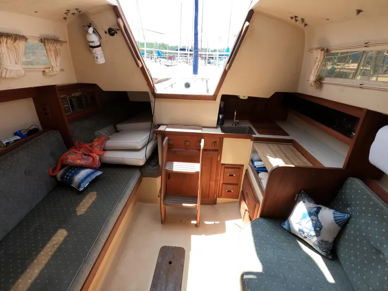 Slide: The Image of Interior of a 1985 Catalina 27 sailboat with seating, cushions, and wooden cabinetry. - 15
