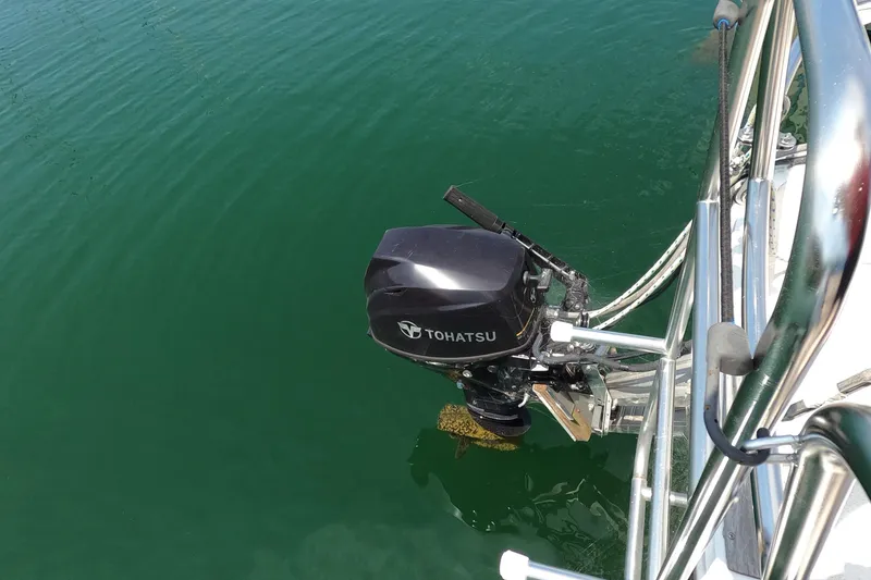 Slide: The Image of Tohatsu outboard motor on a 1985 Catalina 27 sailboat in calm water. - 16
