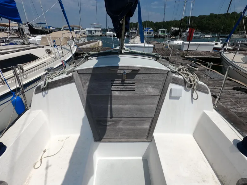 Slide: The Image of 1985 Catalina 27 sailboat cockpit with wooden hatch, docked at marina. - 5