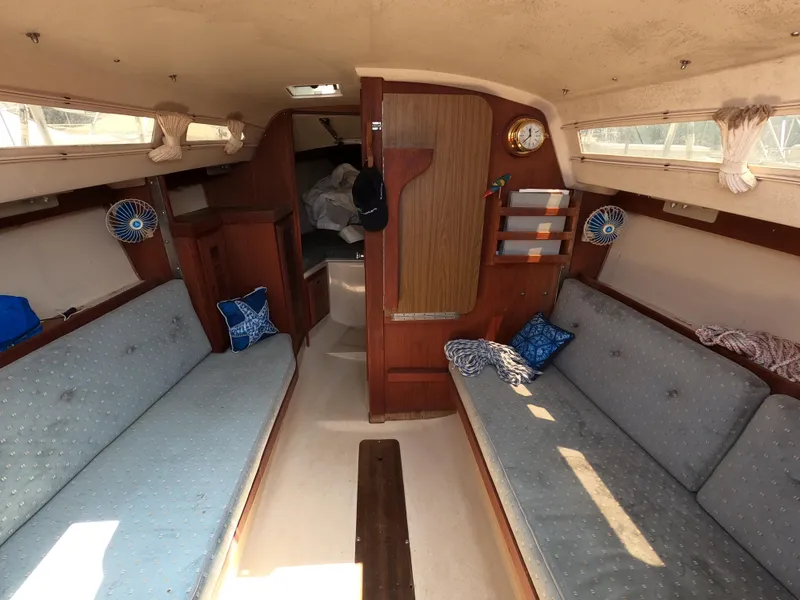 Slide: The Image of Interior of a 1985 Catalina 27 sailboat with cozy seating and wooden accents. - 6