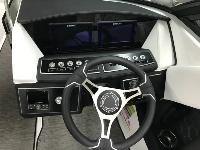 Slide: The Image of 2025 Four Winns H4 boat dashboard with steering wheel and dual Simrad displays. - 23