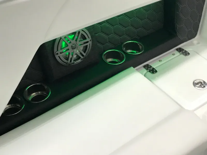 Slide: The Image of 2025 Four Winns H4 boat interior with speaker and cup holders, featuring green lighting. - 50