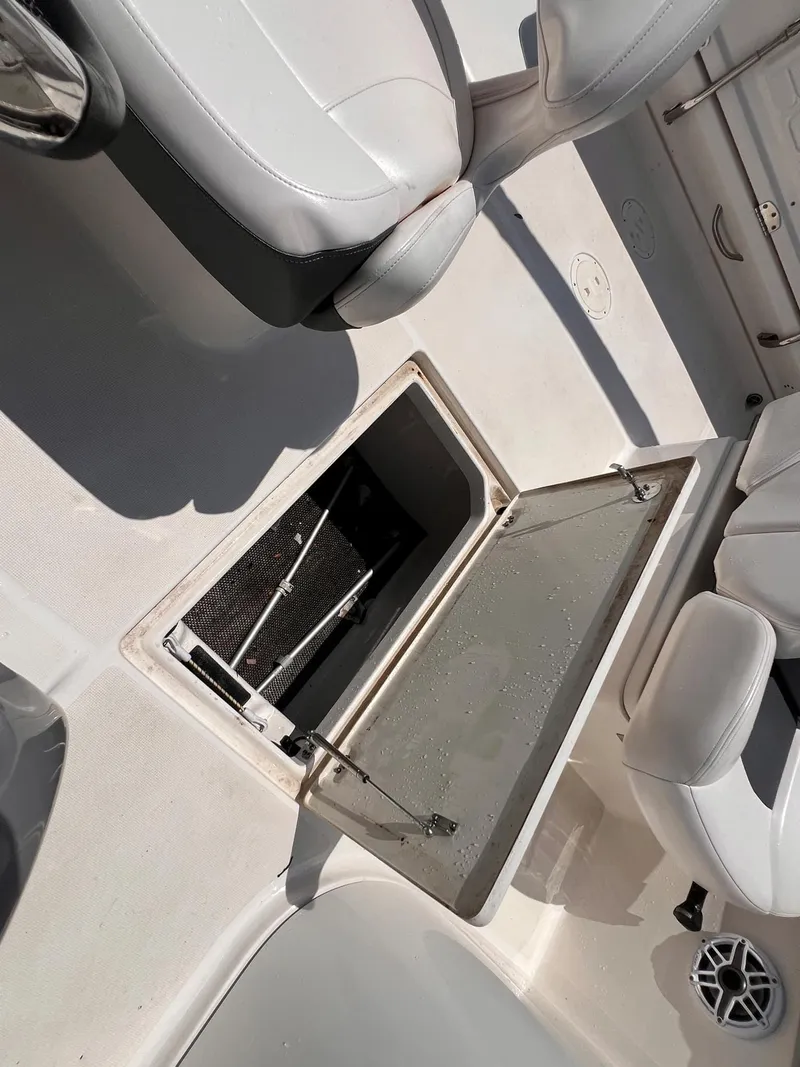 Slide: The Image of 2021 Robalo R227 Dual Console boat interior with open storage compartment. - 12