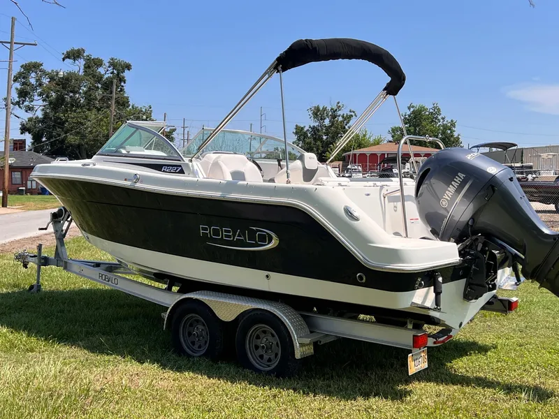 Slide: The Image of 2021 Robalo R227 Dual Console boat on trailer, parked on grass. - 5