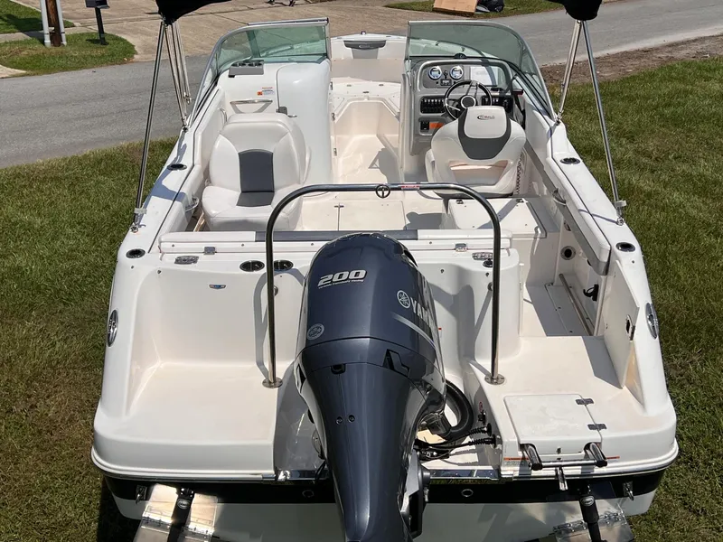 Slide: The Image of 2021 Robalo R227 Dual Console boat with Yamaha 200 engine, parked on grass. - 6
