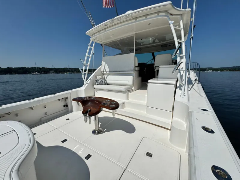 Slide: The Image of 2019 Tiara Yachts 4300 Open, spacious deck, luxurious seating, calm waters, clear sky. - 11