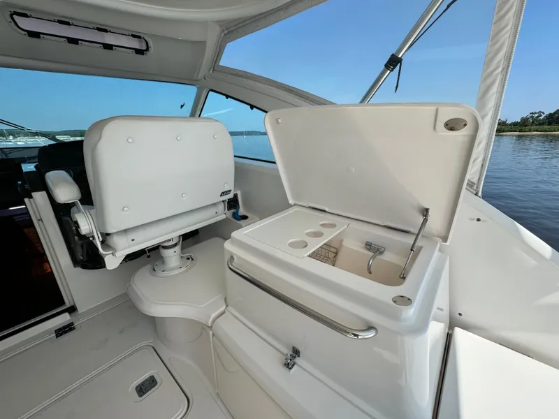 Slide: The Image of 2019 Tiara Yachts 4300 Open cockpit with seating and storage, overlooking serene waters. - 16