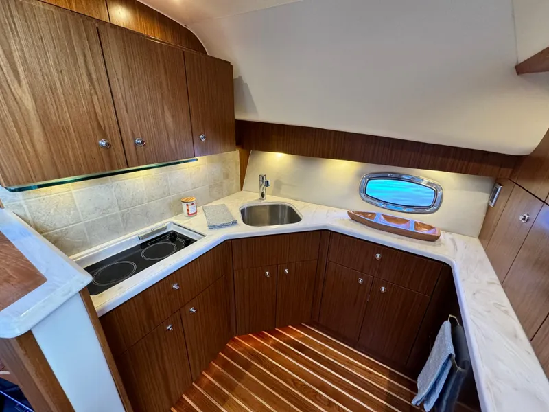 Slide: The Image of 2019 Tiara Yachts 4300 Open galley with wood cabinetry and modern appliances. - 26