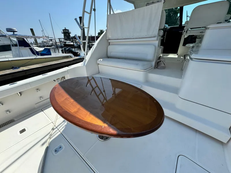 Slide: The Image of 2019 Tiara Yachts 4300 Open with wooden table and white seating on deck. - 31