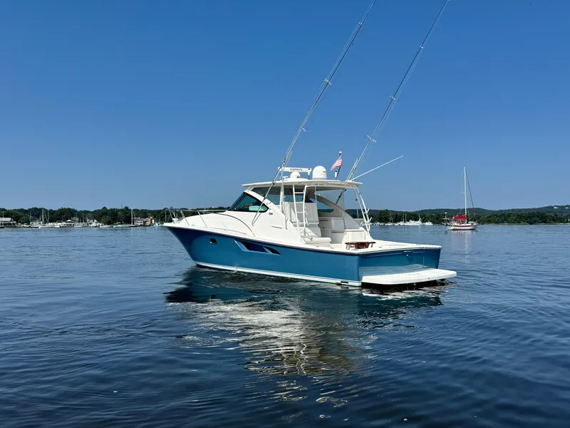 Slide: The Image of 2019 Tiara Yachts 4300 Open on calm water under clear blue sky. - 6