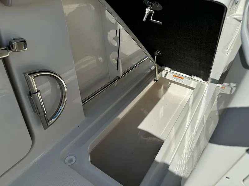 Slide: The Image of 2025 Sailfish 272 CC boat storage compartment with open hatch and sleek design. - 16