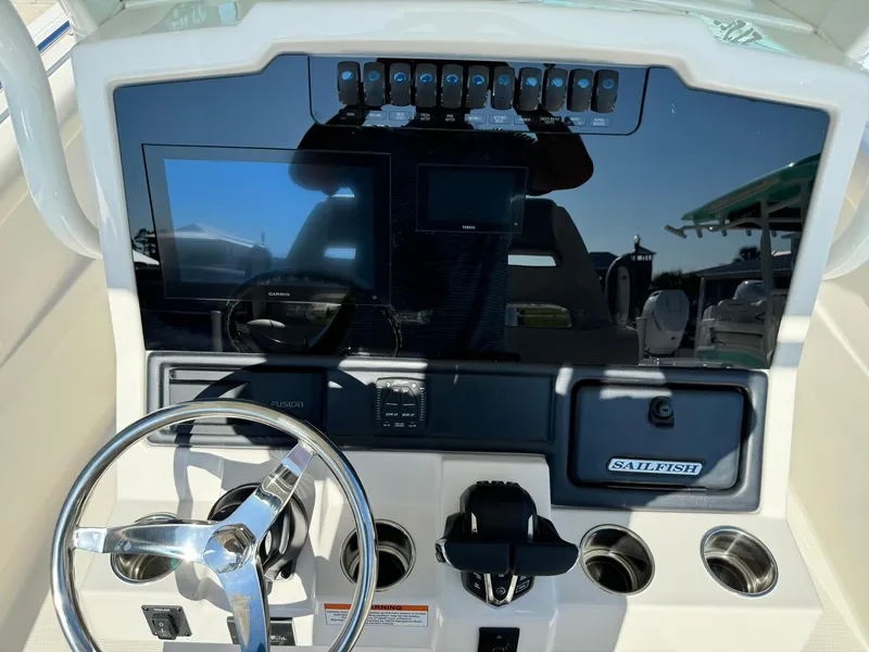Slide: The Image of 2025 Sailfish 272 CC boat dashboard with steering wheel and electronic controls. - 18
