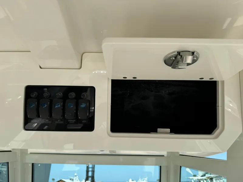 Slide: The Image of 2025 Sailfish 272 CC boat dashboard with control panel and storage compartment. - 22