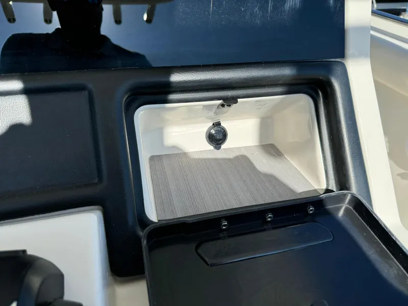 Slide: The Image of 2025 Sailfish 272 CC boat storage compartment with black trim and latch. - 25