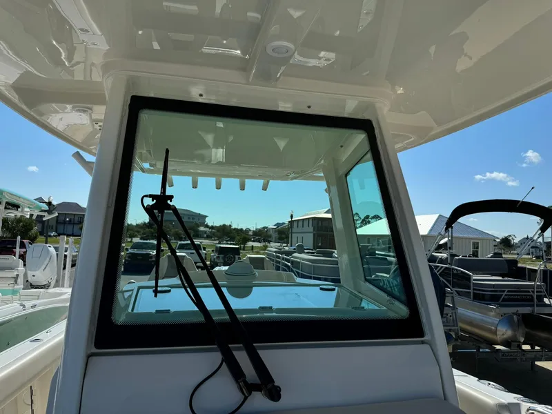 Slide: The Image of 2025 Sailfish 272 CC boat windshield with wiper, docked under clear blue sky. - 39