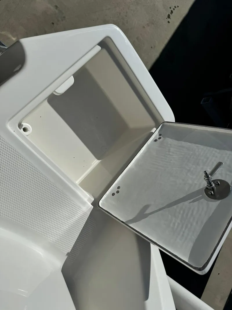 Slide: The Image of 2025 Sailfish 272 CC storage compartment with open lid and key. - 42